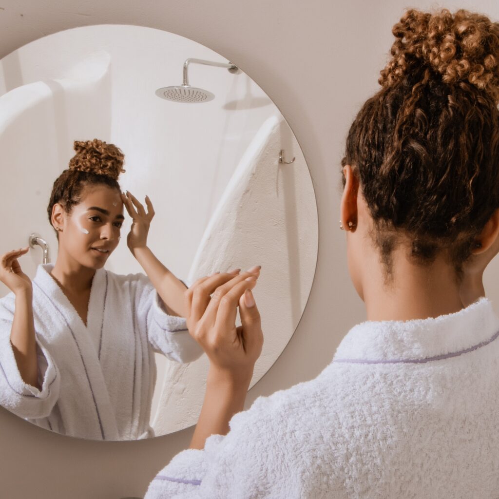 skincare routine Blog 36 Woman performing skincare routine in front of the mirror